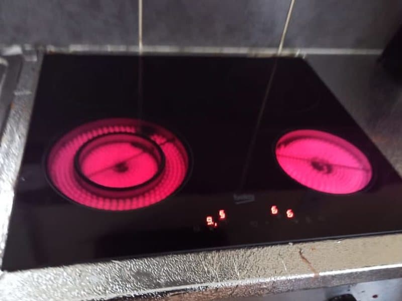 A ceramic electric hob with two rings glowing red during a test.
