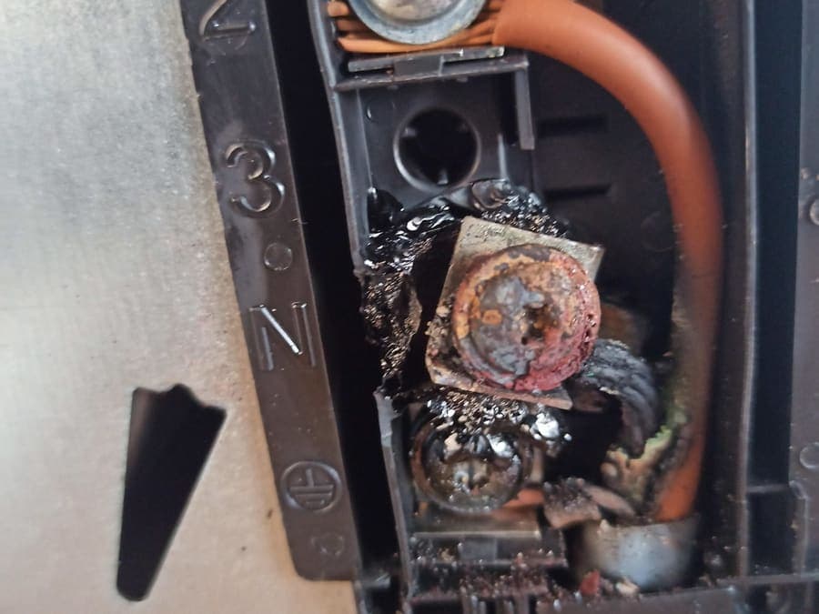 A cooker terminal block with badly burnt and corroded connections.